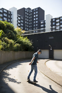 Full length side view of man walking against buildings in city