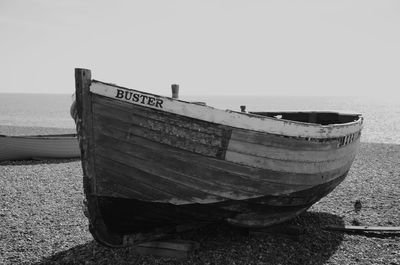 Boat moored on beach against clear sky