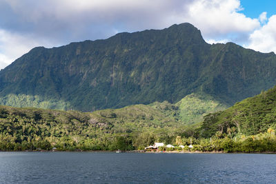 Scenic view of mountains by sea against sky