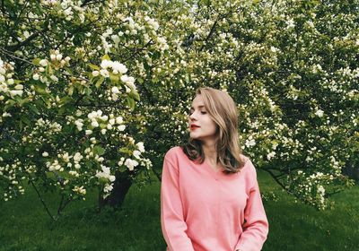 Woman standing against flower tree