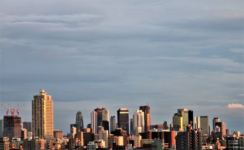 View of skyscrapers against cloudy sky