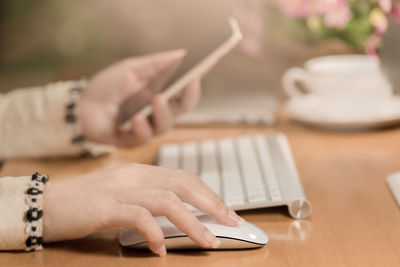 Close-up of hand using laptop on table