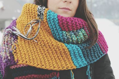 Close-up midsection of woman wearing colorful knitted scarf during winter