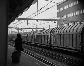 Rear view of woman on railroad station platform in city