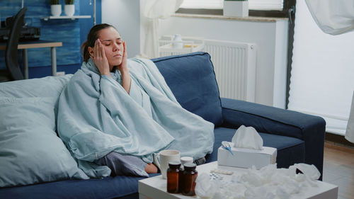 Midsection of woman sitting on bed