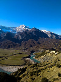 Scenic view of snowcapped mountains against clear blue sky