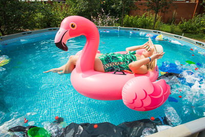 High angle view of woman floating in swimming pool