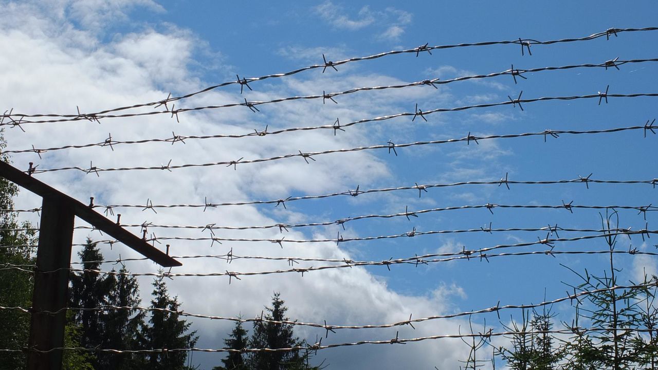 sky, power line, low angle view, cable, electricity pylon, connection, power supply, fence, cloud - sky, electricity, cloud, barbed wire, protection, tranquility, safety, nature, cloudy, fuel and power generation, security, no people