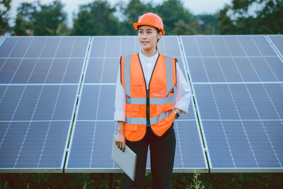 Portrait of businessman standing against solar panel