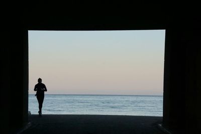 Man looking at sea against clear sky