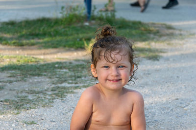 Portrait of cute girl sitting at beach 