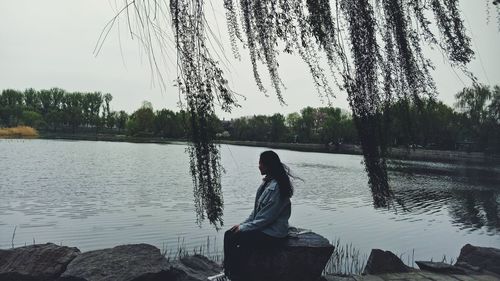 Woman standing on lake against sky