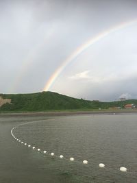 Rainbow over landscape against sky