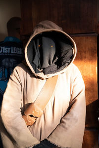 Man dressed up standing against wood wall