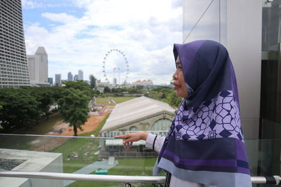 Side view of young woman standing in city