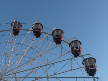 Low angle view of ferris wheel against clear blue sky