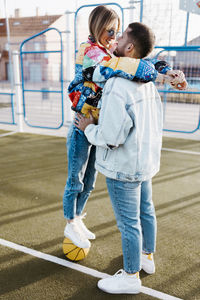 Couple touching her noses on a basketball court. girl on the basket ball. happy girlfriend 