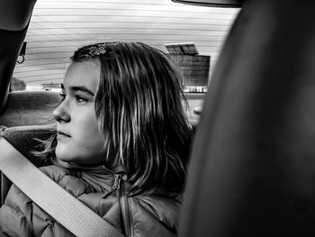 Close-up of thoughtful girl traveling in car