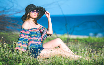 Young woman wearing sunglasses hat on land