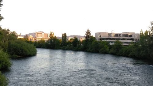 River by buildings against clear sky