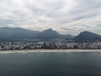Scenic view of sea and mountains against sky