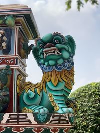 Low angle view of statue against sky and building