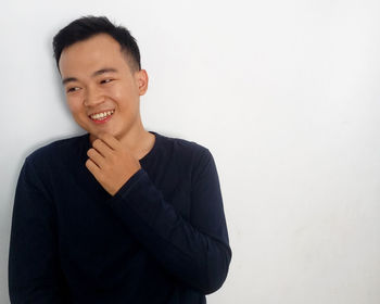 Portrait of a smiling young man against white background