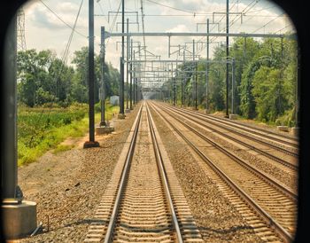 Railroad tracks amidst trees against sky