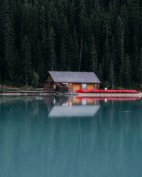 Built structure by lake against trees in forest