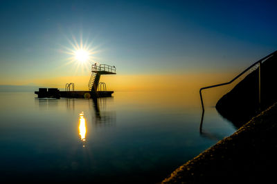 Silhouette boat in sea against sky during sunset