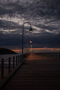 Pier over sea against sky at sunset