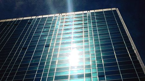 Low angle view of modern building against blue sky