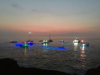 Sailboats in sea against sky during sunset