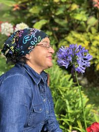 Side view of woman looking at purple flowering plants