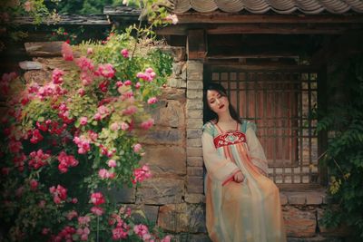 Woman standing by flowering plants