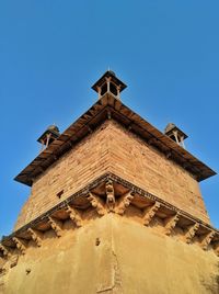 Low angle view of historic building against clear blue sky