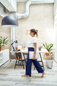 Freelancer with laptop walking at home office