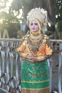 Woman wearing traditional clothing while standing against railing