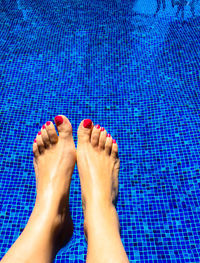 Low section of woman's legs in swimming pool