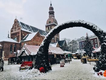 Buildings in city against sky during winter