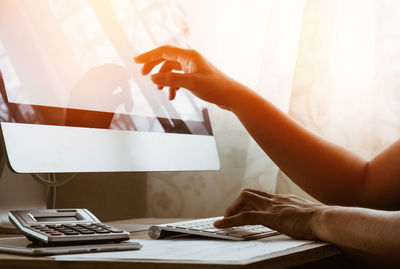 Cropped image of hands working on computer at office