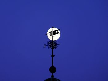 Low angle view of illuminated street light against clear blue sky