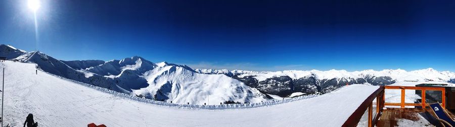 Panoramic view of snowcapped mountains against blue sky