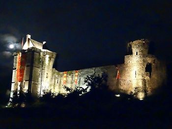 Low angle view of illuminated building against sky at night