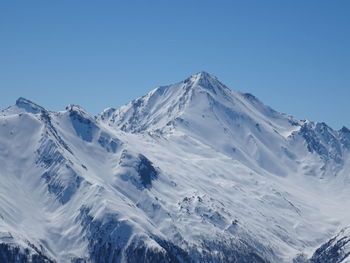 Scenic view of snowcapped mountains against clear blue sky