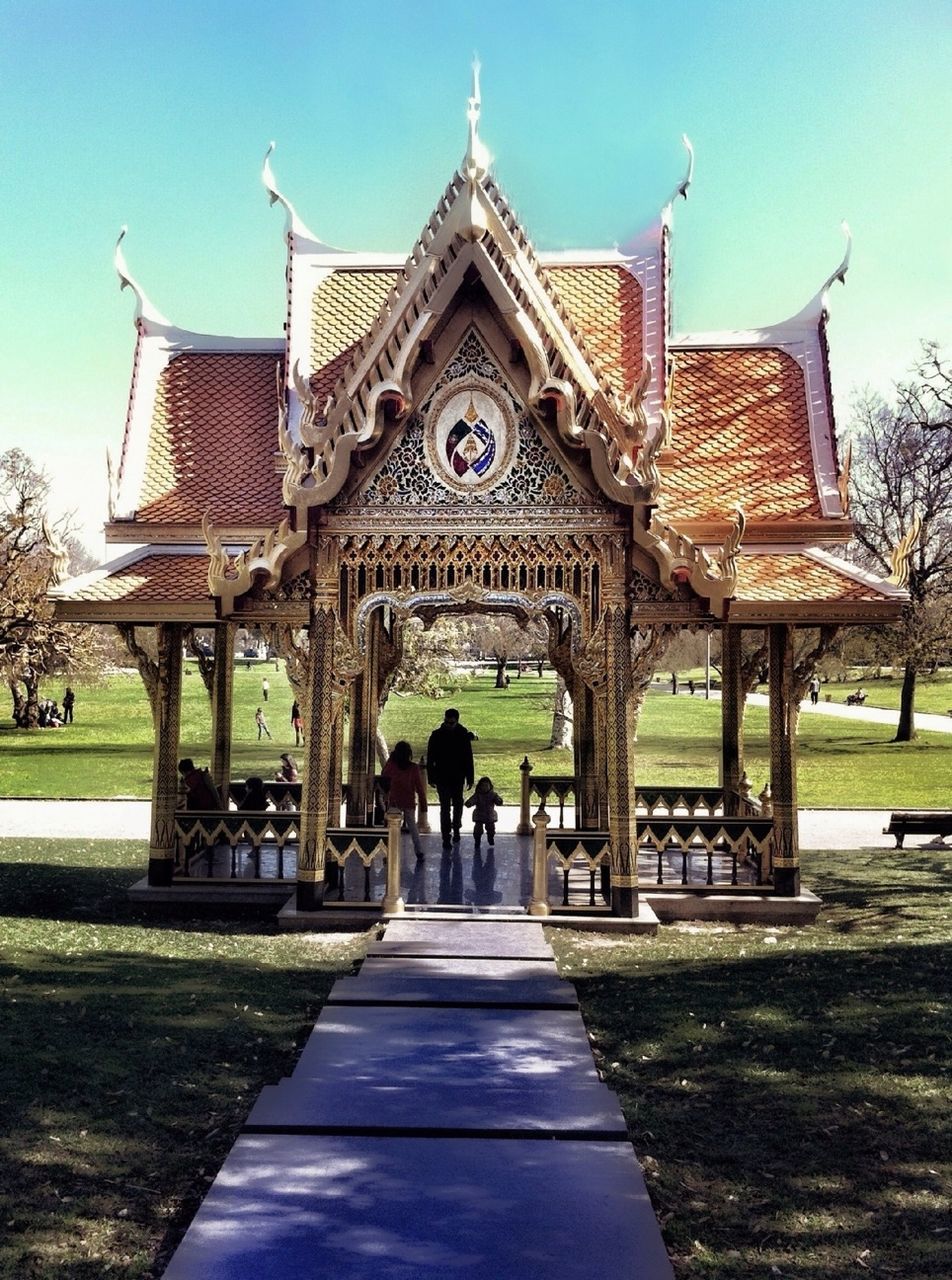 built structure, architecture, building exterior, clear sky, sky, sunlight, incidental people, place of worship, shadow, footpath, tree, religion, blue, the way forward, travel destinations, spirituality, outdoors, gazebo, park - man made space, day