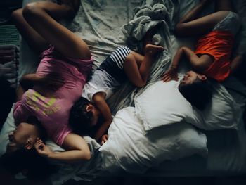 High angle view of people relaxing on bed