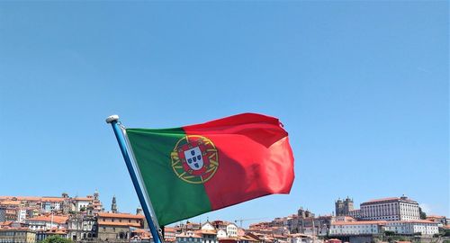 Low angle view of flag against clear blue sky