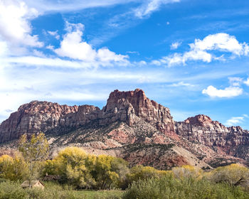 Rock formations on landscape against cloudy sky