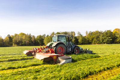 Tractor mowing grass in meadow